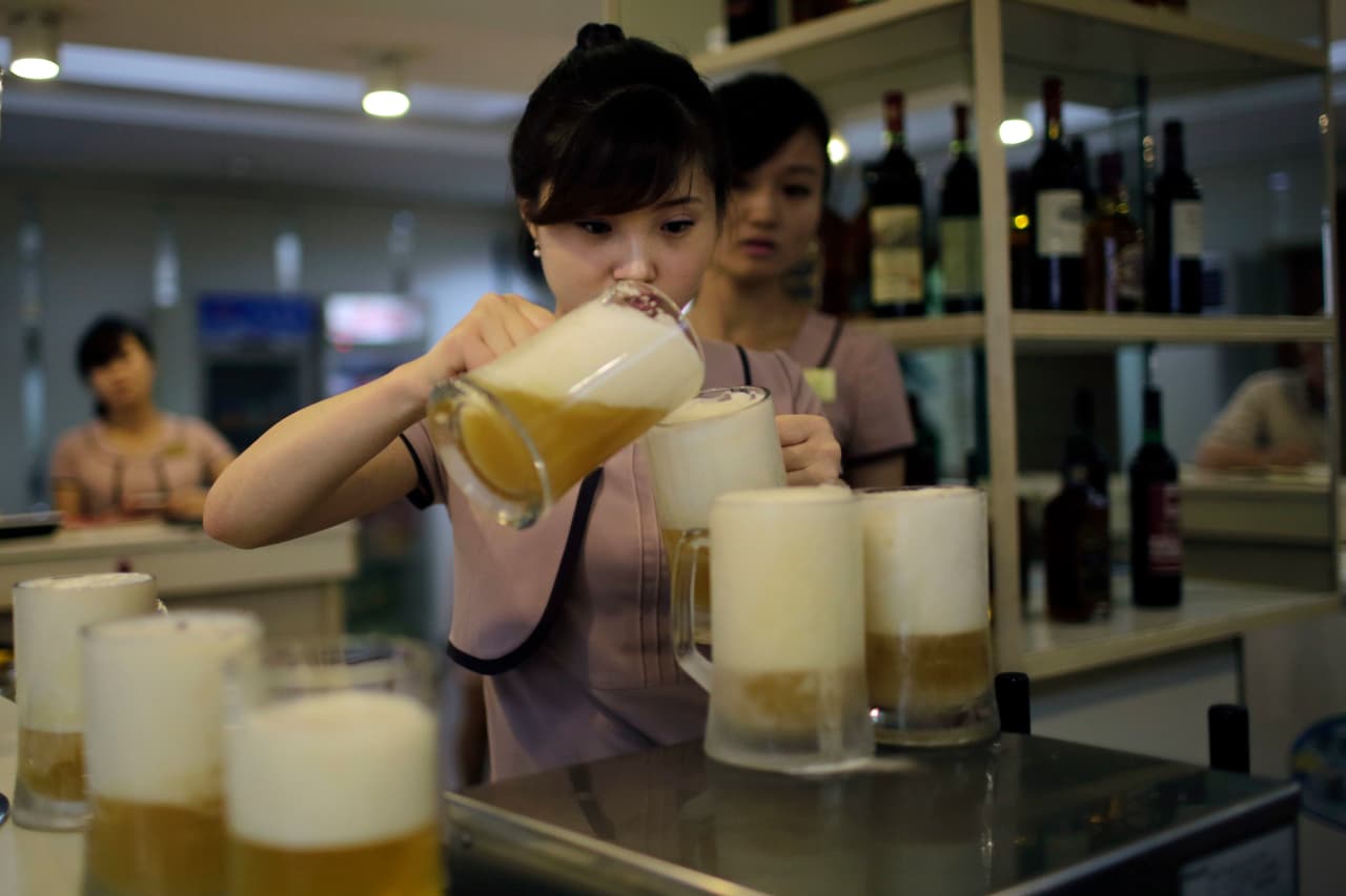 Una mesera sirve un nuevo tipo de cerveza lanzado en 2017 por la fábrica estatal. La cervecería Taedonggang produce 53,000 galones de cerveza diariamente para satisfacer la demanda de la capital norcoreana, de unos 3 millones de habitantes.