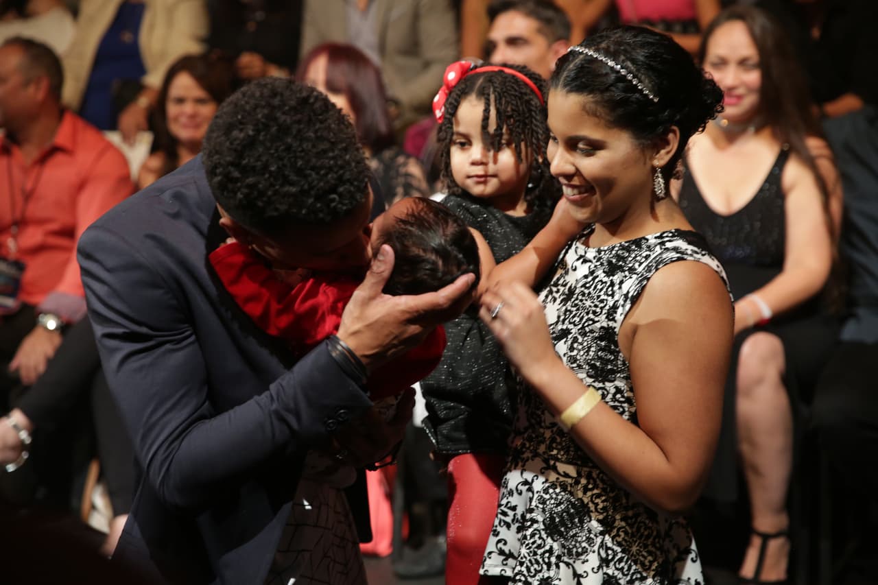Un besito entre la orgullosa mirada de su esposa.