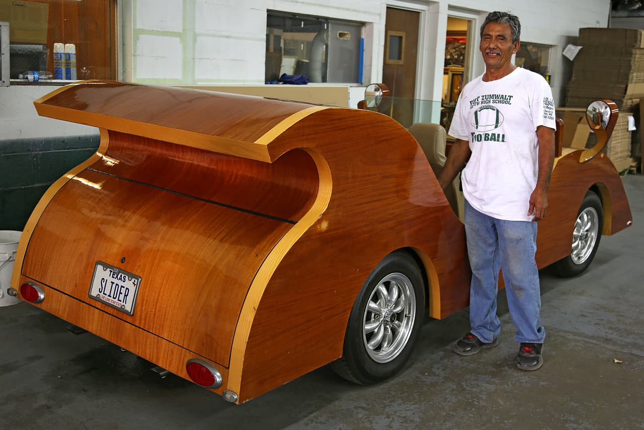 José, uno de los empleados de Isaac Cohen, ayuda con el cuidado y mantenimiento de los coches de madera.