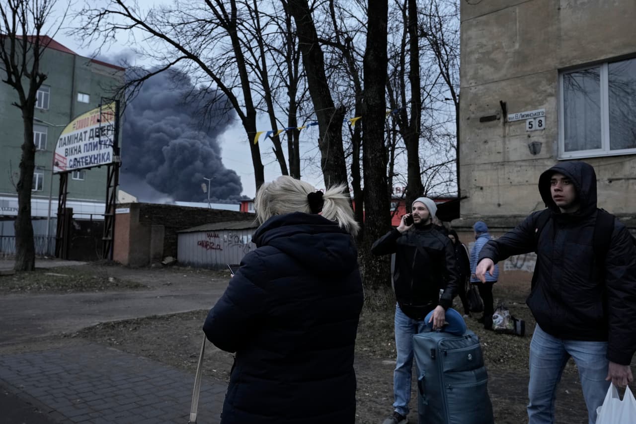 <b>Leópolis se había convertido en una especie de 'puerto seguro' para miles de ucranianos que huyen de sus ciudades y pueblos devastados situados más al este en el país.</b> Las autoridades calculan que unos 200,000 ucranianos desplazados se refugian allí.
<br>
<br>En la foto, los transeúntes miran el humo negro en Leópolis.