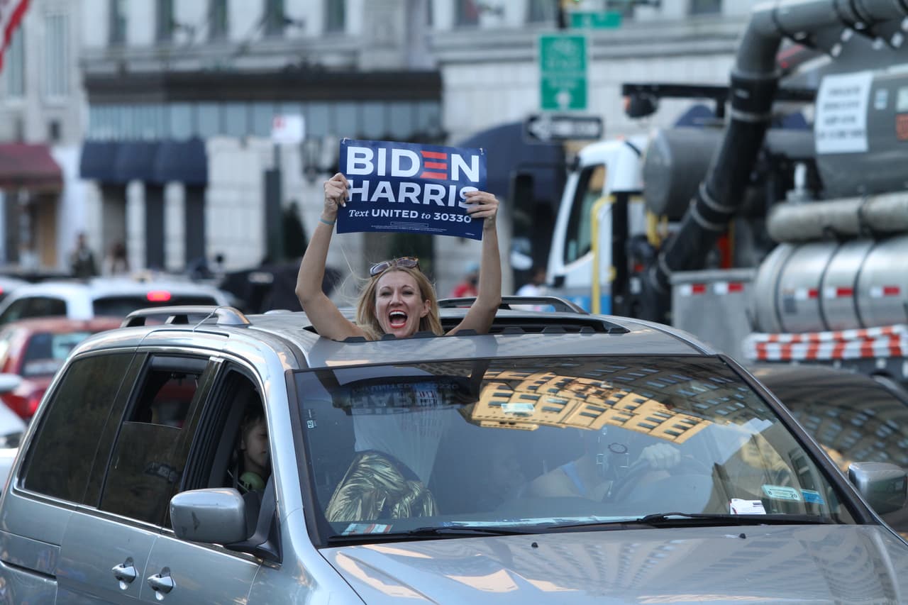 Simpatizante de Joe Biden grita y celebra desde su carro mientras transita por una de las calles cercanas a Columbus Circle.