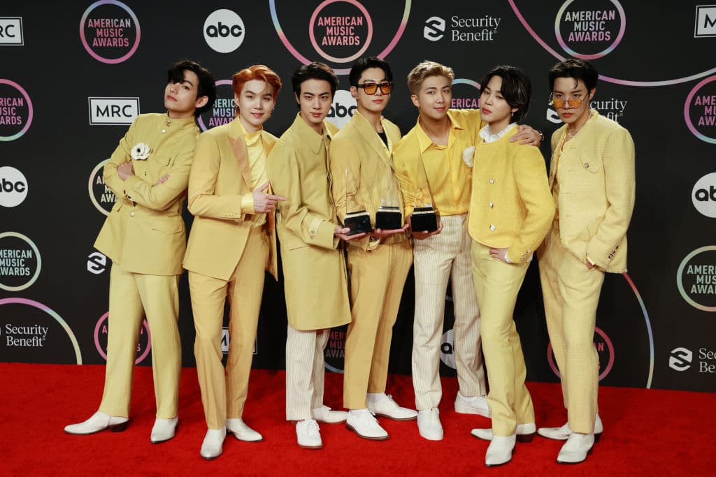LOS ANGELES, CALIFORNIA - NOVEMBER 21: (L-R) V, Suga, Jin, Jungkook, RM, Jimin, and J-Hope of BTS, winners of the Favorite Pop Song, Favorite Pop Duo or Group, and Artist of the Year awards, pose in the press room during the 2021 American Music Awards at Microsoft Theater on November 21, 2021 in Los Angeles, California. (Photo by Matt Winkelmeyer/Getty Images for MRC)