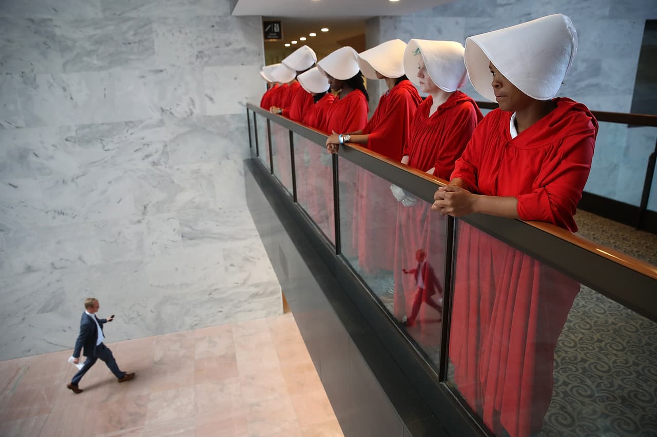 WASHINGTON, DC - SEPTEMBER 04: Protesters dressed in The Handmaid's Tale costume, protest outside the hearing room where Supreme Court nominee Judge Brett Kavanaugh will testify before the Senate Judiciary Committee during his Supreme Court confirmation hearing in the Hart Senate Office Building on Capitol Hill September 4, 2018 in Washington, DC. Kavanaugh was nominated by President Donald Trump to fill the vacancy on the court left by retiring Associate Justice Anthony Kennedy. (Photo by Win McNamee/Getty Images)