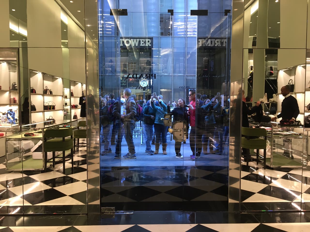 Desde la tienda de lujo Prada en la Quinta Avenida, así se ven los turistas y otros curiosos de la Torre Trump tomándose 'selfies'.
