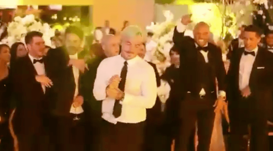 J Balvin, al centro, mientras se preparaba para dar una voltereta en la pista de baile, en la boda de Nicky Jam.