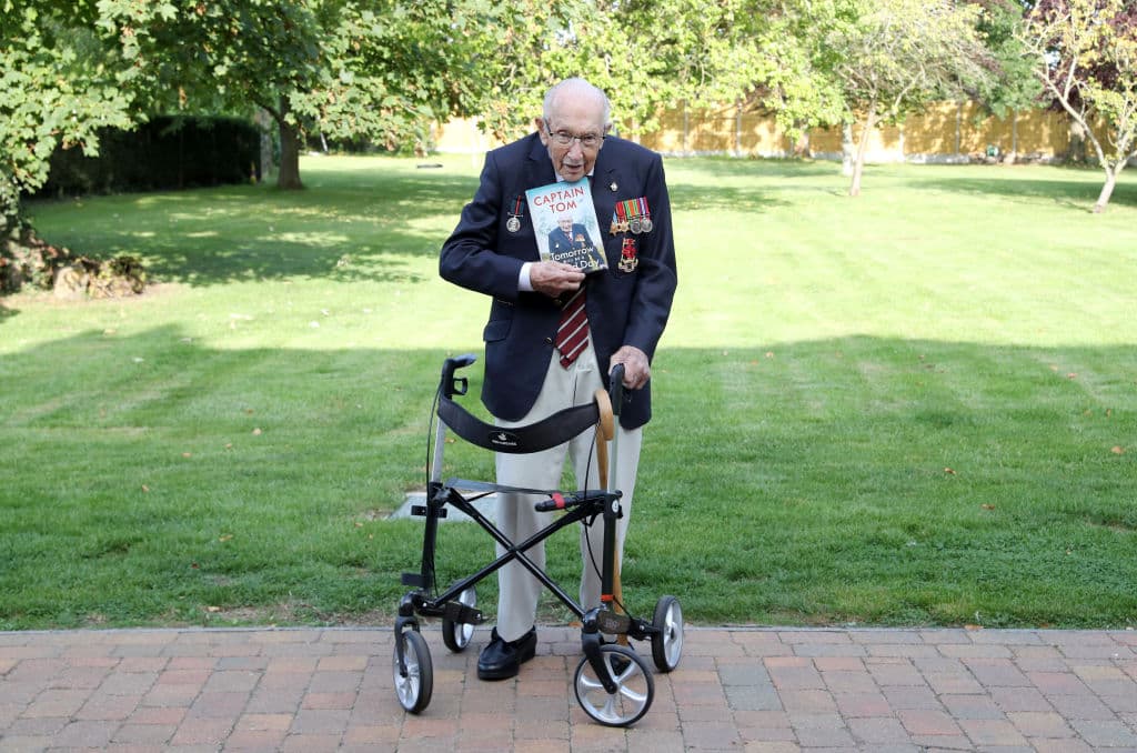 El capitán Tom Moore, un veterano de guerra británico, le dio 100 vueltas a su jardín en abril usando sus medallas de servicio y su andadera como apoyo con lo que logró reunir 33 millones para el servicio de salud.