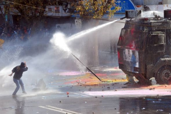 La manifestación, a la que se plegaron universitarios que exigen un mayor aporte público a la educación superior, así como obreros y damnificados del terremoto del 27 de febrero de 2010, derivó en violentos choques con piedras y palos entre los manifestantes y la policía, que recurrió a carros de agua y gases lacrimógenos para disolver la protesta.