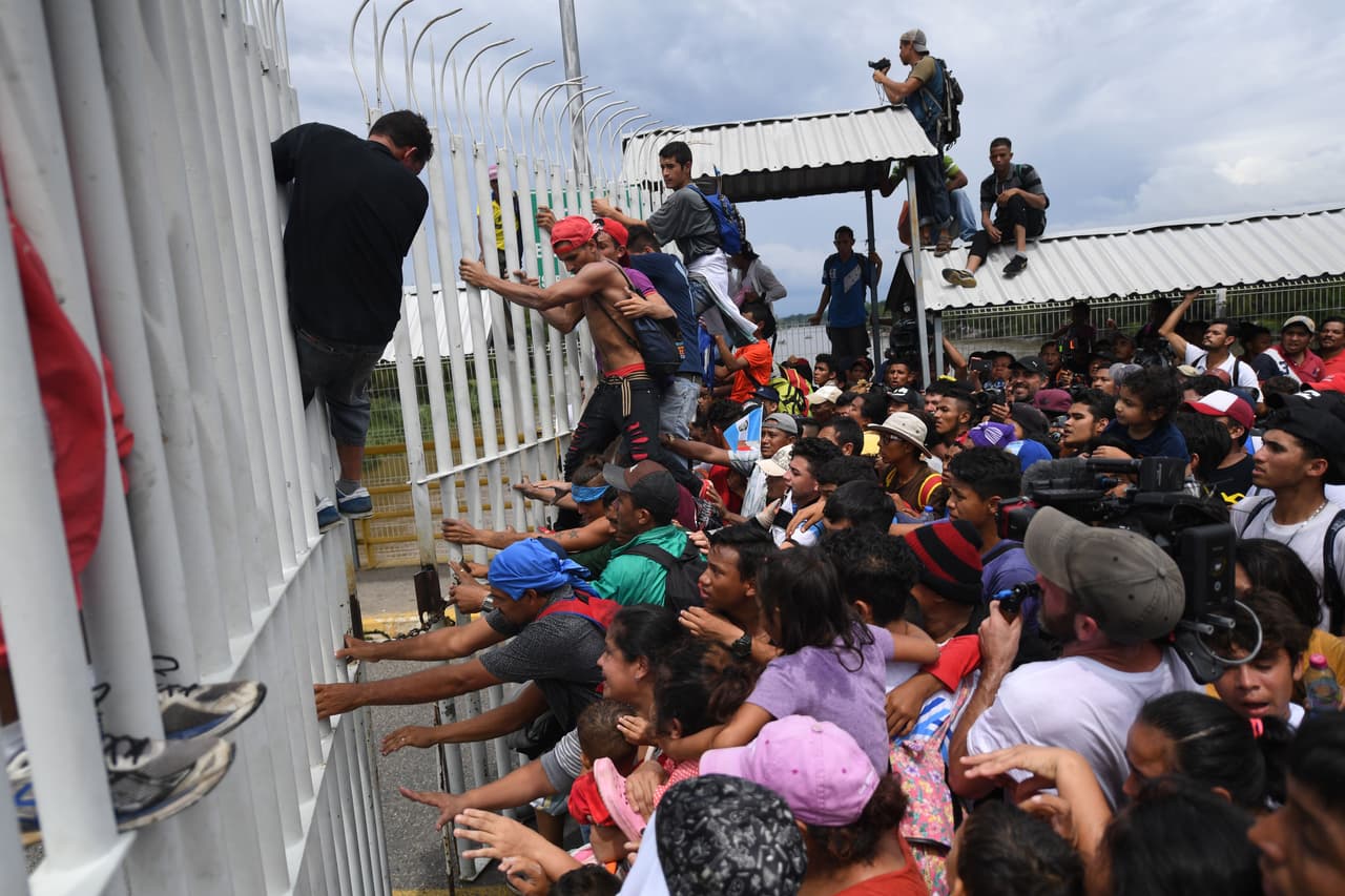 Caravana de migrantes cruza masivamente la frontera de Guatemala rumbo a México rompiendo la cerca del control fronterizo