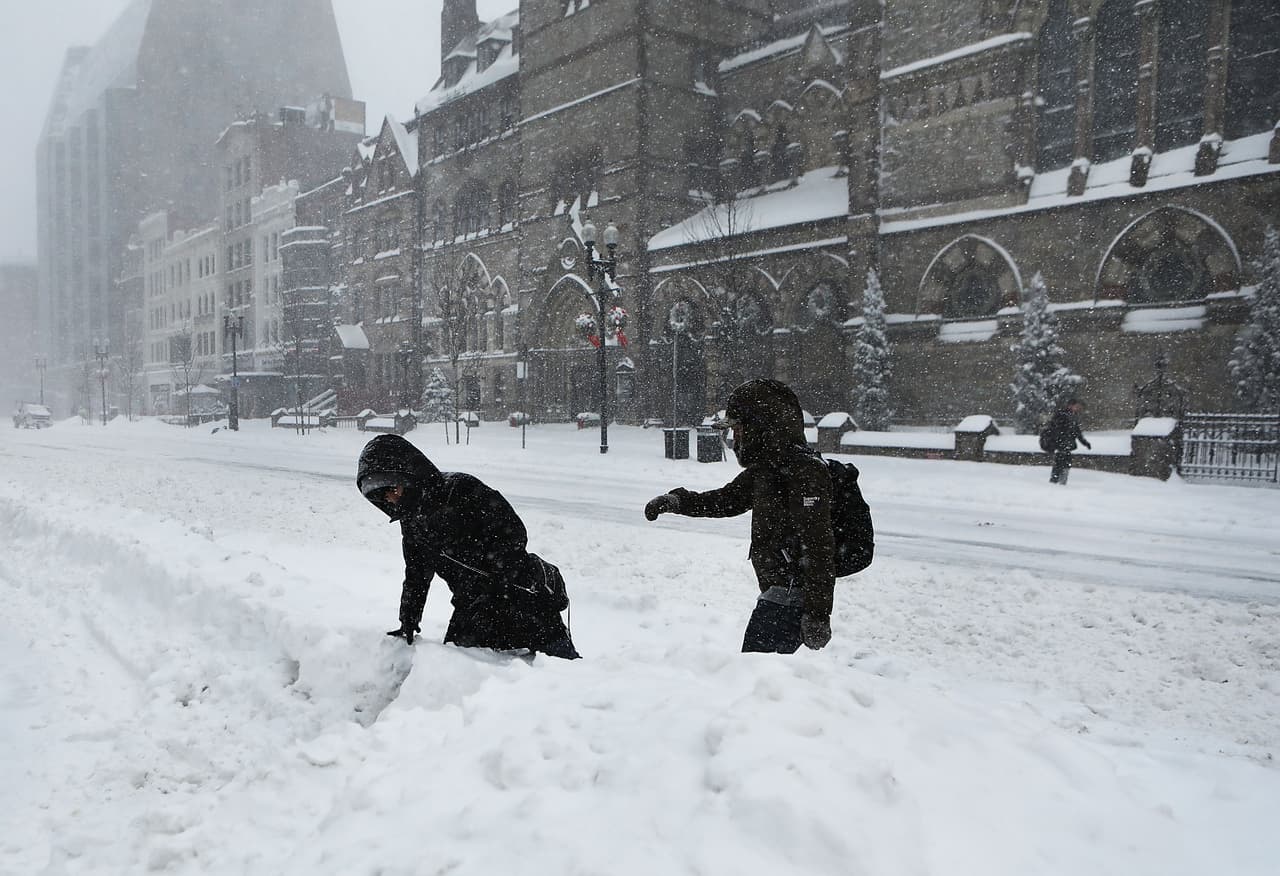 Dos peatones luchan para caminar por una calle nevada en Boston, Massachusetts.