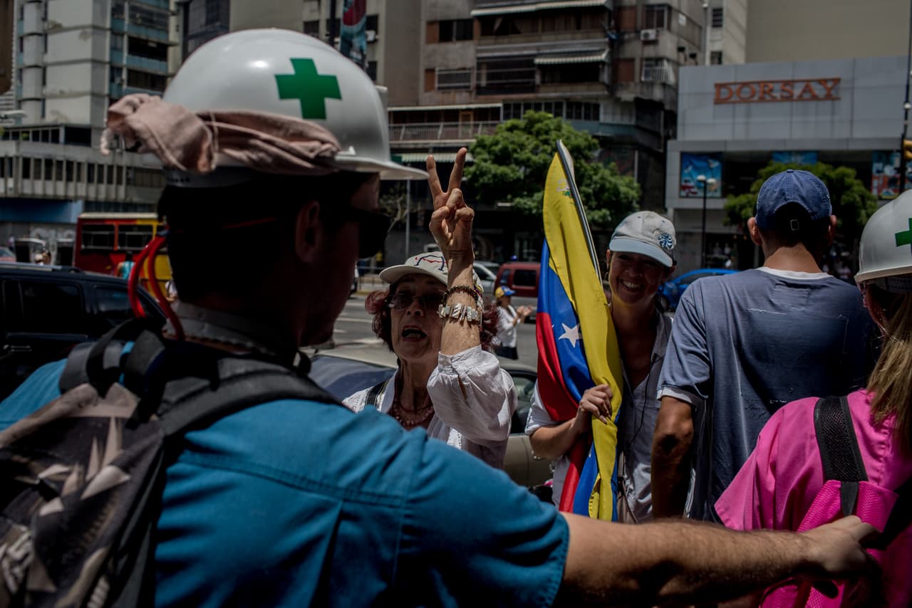 The activists stop chanting their slogans and applaud when volunteers go by. The street clashes have continued for 45 days, resulting in a variety of injuries from blunt trauma, to burns and gunshot wounds. Severl people have been run over by armored vehicles. More than 40 have died since the protests began in April.