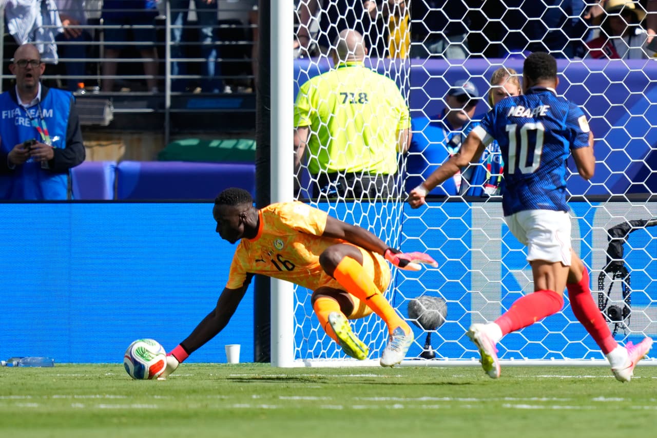 El portero de Senegal, Edouard Mendy, detiene un disparo a puerta del francés Kylian Mbappé (a la derecha) durante el partido de fútbol del Grupo I de la Copa del Mundo entre Francia y Senegal en East Rutherford, Nueva Jersey.