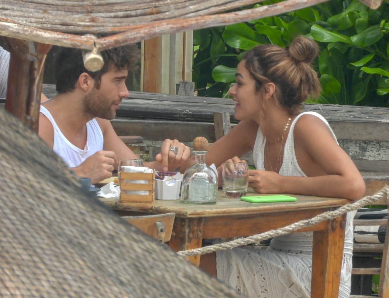 Usando una camiseta blanca, el actor lucía sonriente y tranquilo, mientras escuchaba a su acompañante con atención.