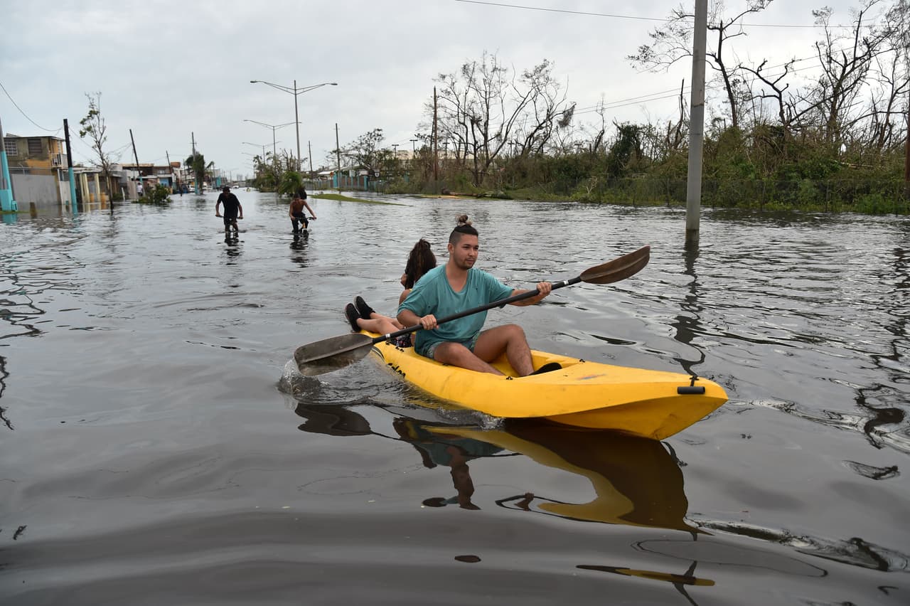 Residentes de Catano, Juana Matos, se desplazan navegando en las calles inundadas.