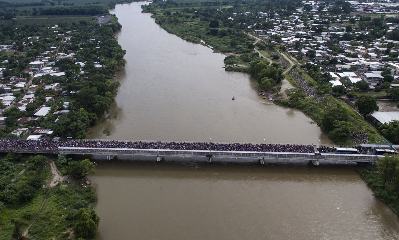 Una vista aérea de la caravana de migrantes en el puente sobre el río Suchiate. A la derecha del río está México.