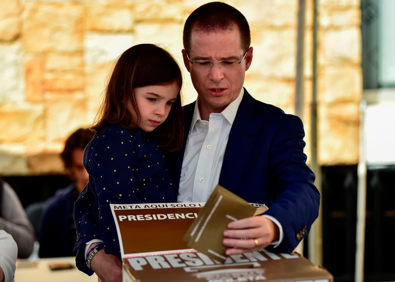 El candidato depositó la boleta electoral con su hija Carmen en brazos.