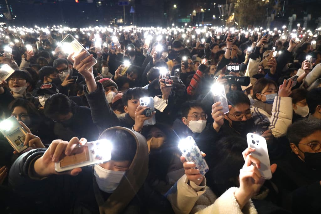 Cientos de personas se congregan para recibir el año en el Pabelón Bosingak de Seúl, Corea del Sur, con las linternas de sus celulares encendidas.