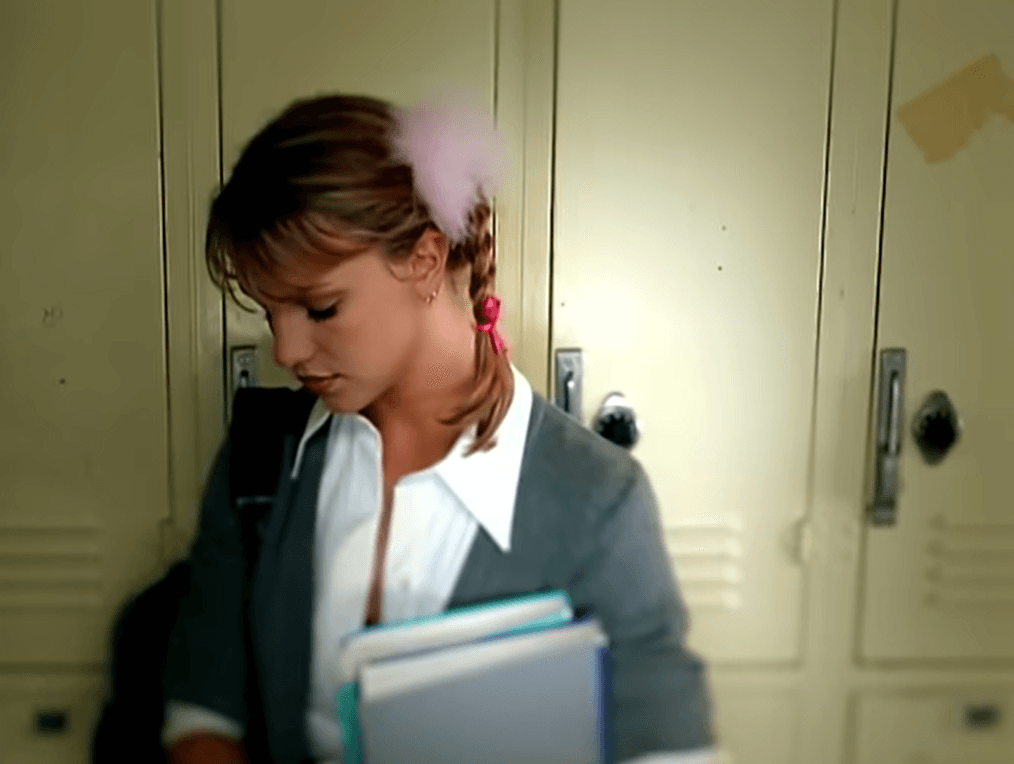 Las botas hasta la rodilla, la falda negra, una camisa blanca con botones atada para mostrar su cintura, un cárdigan gris y, por supuesto, coletas trenzadas adornadas con pompones rosas, ¡inolvidable!