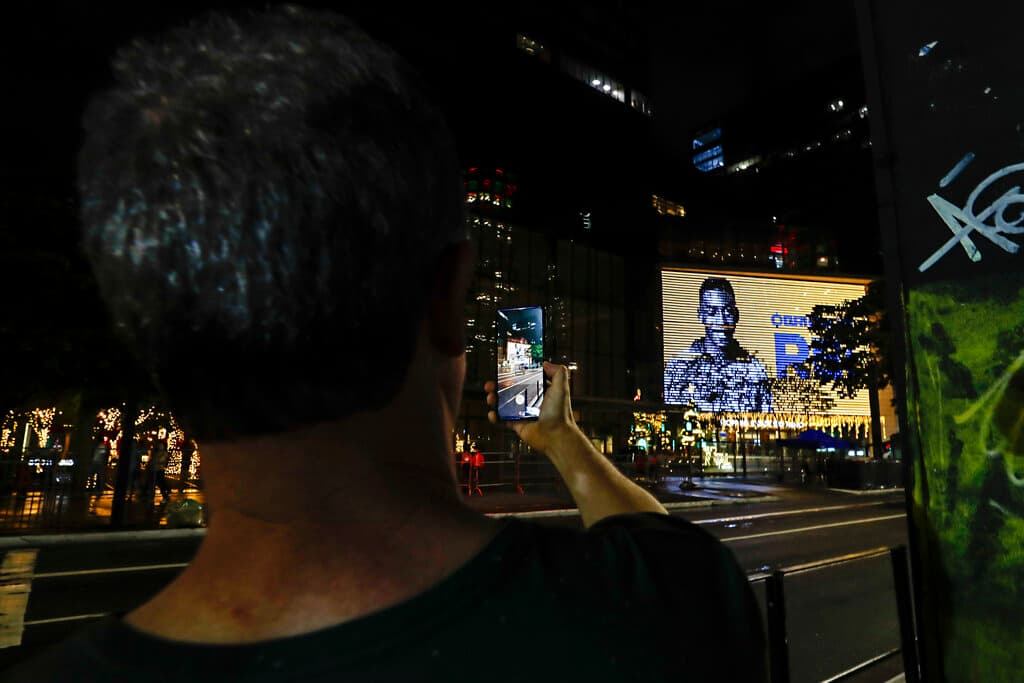 Una persona toma una foto de una imagen Pelé que se reproduce en el centro comercial Cidade de Sao Paulo. Imágenes del astro coparon los informativos, las redes sociales y las portadas de todo el planeta. "Muere Pelé, el Rey inmortal del Fútbol", dice la web del diario
<i>O Globo</i>, junto a un editorial con el título: "Nunca habrá nadie que se compare a Pelé".