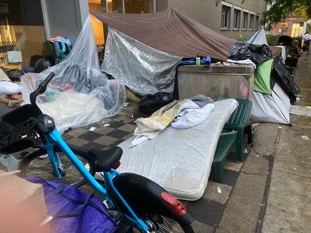 Techos improvisados con sábanas y bolsas plásticas son usados por migrantes para protegerse de la lluvia durante la noche.