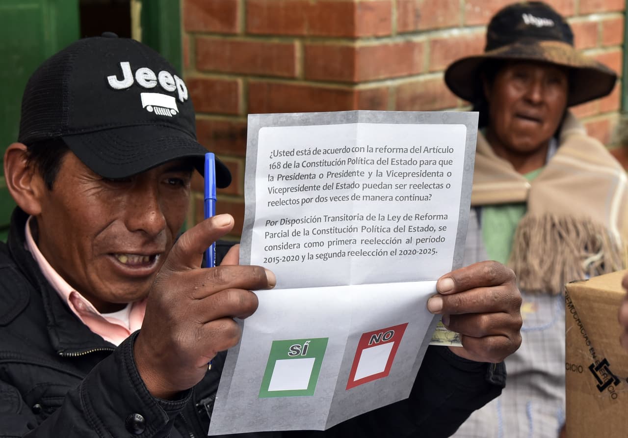 Un juez de la elección muestra la papeleta que usan los votantes.
