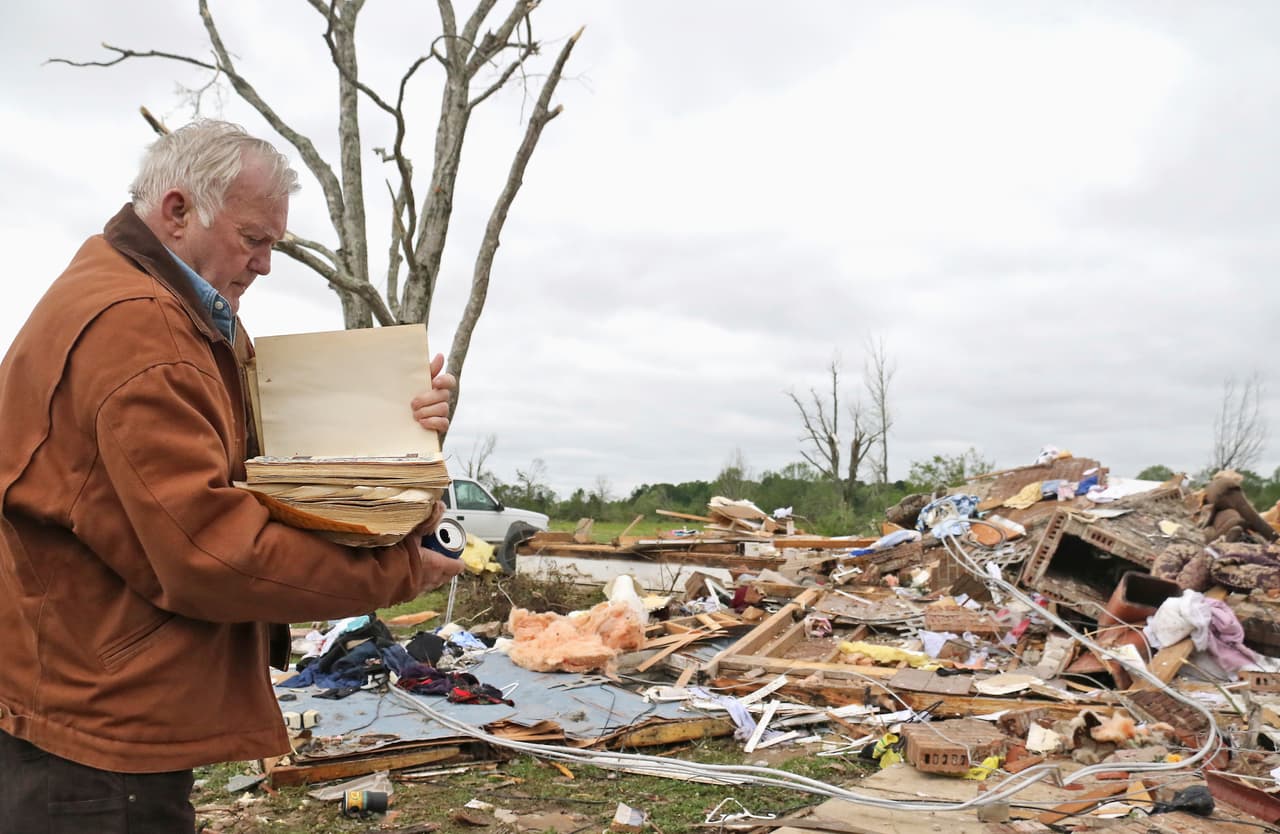 Robert Scott rescata una biblia de los escombros en su casa destruida en Hamilton, Mississippi.