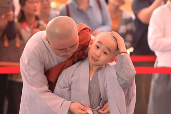 Este otro pequeño es atendido por uno de sus líderes, quien le ayuda a cerrarse su túnica.