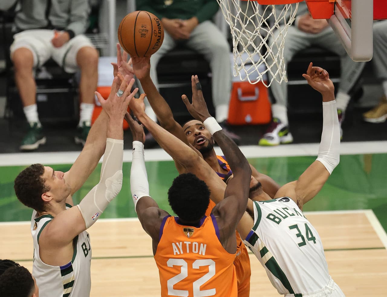 Brook Lopez # 11 y Giannis Antetokounmpo # 34 de los Milwaukee Bucks suben por un rebote contra Mikal Bridges # 25 y Deandre Ayton # 22 de los Phoenix Suns durante la segunda mitad del Juego Cuatro de las Finales de la NBA en el Fiserv Forum el 14 de julio. 2021 en Milwaukee, Wisconsin.