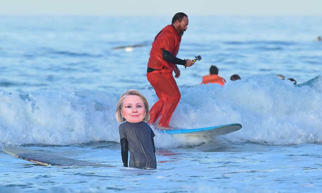Un surfista con una máscara de Clinton corre olas en una competencia en Newport Beach, California. (Frederic Brown/AFP/Getty Images)