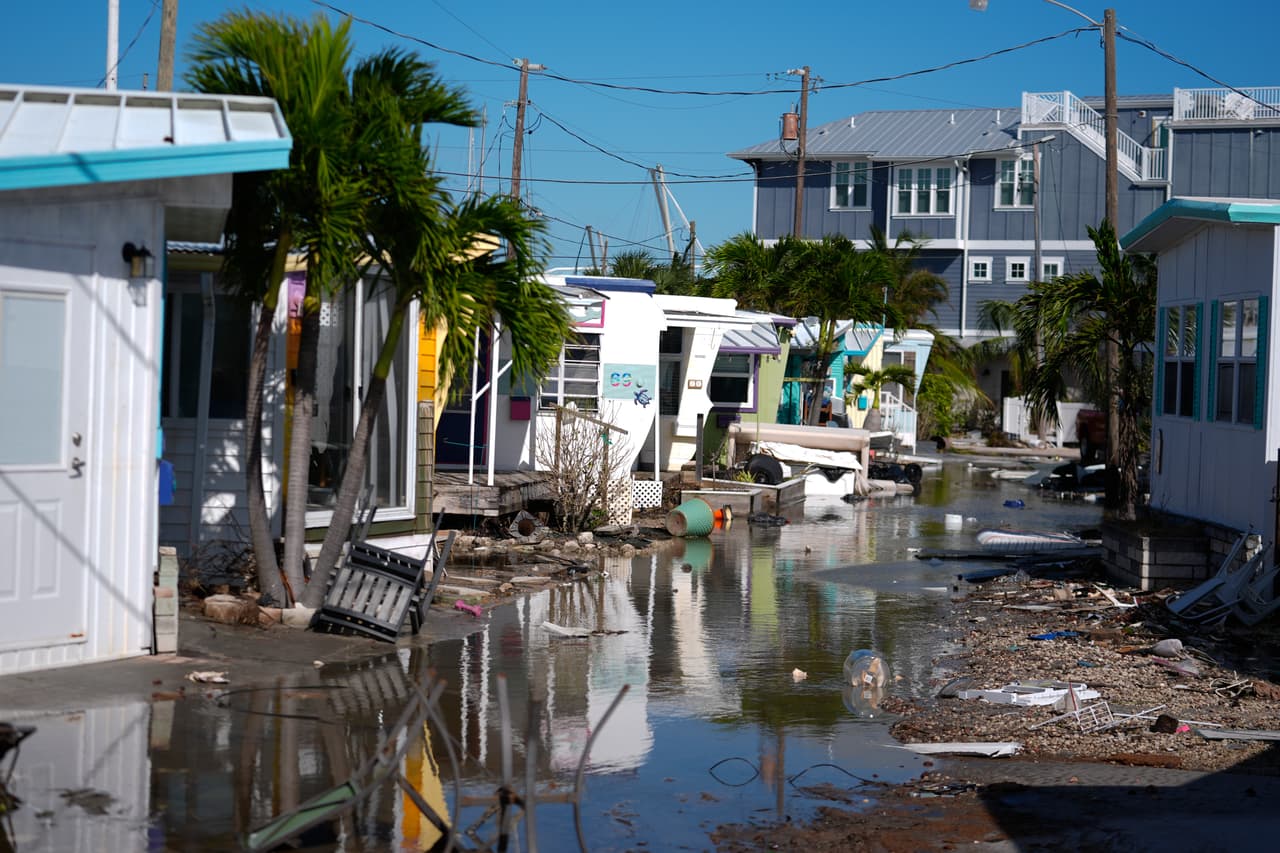 El agua que dejó el huracán Milton inunda una calle dentro de Pines Trailer Park, donde todavía había escombros amontonados afuera de las casas luego del huracán Helene, en Bradenton Beach.