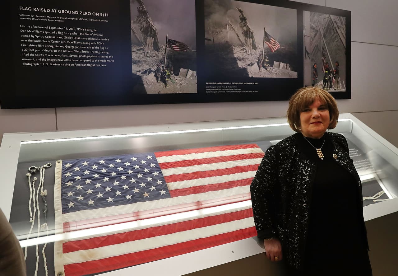 Shirley B. Dreifus, viuda de Spiro E. Kopelaki, posa frente a la bandera que el 11 de septiembre de 2001 fue tomada por los bomberos del yate de su esposo para inspirar al mundo.