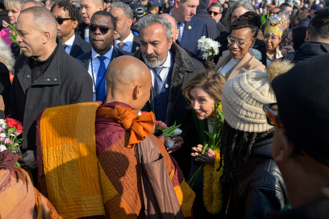 El líder de la minoría de la Cámara de Representantes, Hakeem Jeffries, demócrata por Nueva York, a la izquierda, y la representante Nancy Pelosi, demócrata por California, a la derecha, saludan a monjes budistas mientras caminan cerca del Monumento a la Paz en el Capitolio, durante la Caminata por la Paz, en Washington, el miércoles 11 de febrero de 2026.