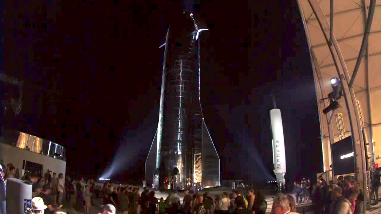 La nave espacial, una estructura plateada y brillante, fue diseñada para transportar a decenas de personas y ocupa mitad superior del colosal sistema de cohetes reutilizables de SpaceX. "Este es básicamente el santo grial del espacio", dijo Musk, de pie entre un cohete Starship recién fabricado y el Falcon 1, la primera nave de SpaceX.