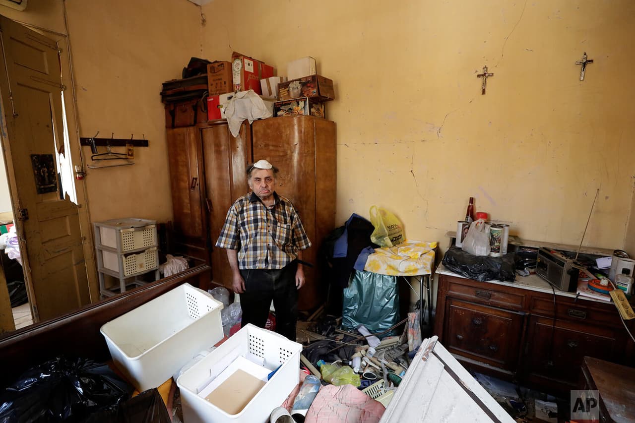 Waleed Mokbel, de 78 años, posa para una fotografía dentro de su apartamento destruido.
<b> Con el gesto abatido y cansado, Waleed contempla la destrucción de su hogar.</b>