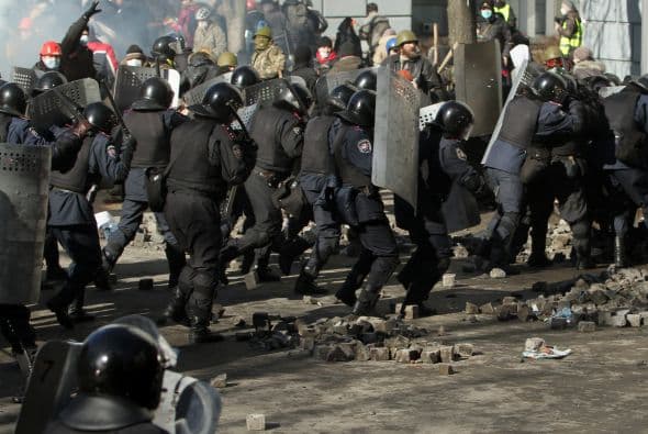 La policía ucraniana cercó hoy a los manifestantes en el corazón de las protestas opositoras de la plaza de la Independencia de Kiev (Maidán), tras una jornada en la que murieron 14 personas en los disturbios que estallaron en la capital. Víktor "Yanukóvich se ha convertido en un presidente sangriento", aseguró hoy el dirigente opositor Vitali Klitschkó en un llamamiento a los países democráticos para que intervengan en Ucrania y frenen la violenta confrontación. Según se acercaba la medianoche, los temidos Berkut, el destacamento antidisturbios, estrechaban el cerco en torno a los miles de manifestantes concentrados en el Euromaidán, bastión de las protestas desde el pasado 21 de noviembre. "Los extremistas de la oposición han cruzado la línea roja; matan a inocentes en la calles de la capital de Ucrania, vejan a mujeres, queman edificios y automóviles. Y si los disturbios continúan, nos veremos obligados a actuar con firmeza", rezaba el ultimátum del Servicio de Seguridad y el Ministerio del Interior de Ucrania. Advierten a los americanos que se queden dentro de las casas y de nuevo se sienten explosiones en la ciudad.