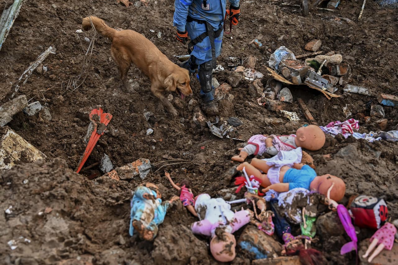Manuel Bermudez, miembro de la Cruz Roja de Colombia, con su perra Gretta buscan sobrevivientes tras el deslave en Rosas, Valle del Cauca, Colombia.
