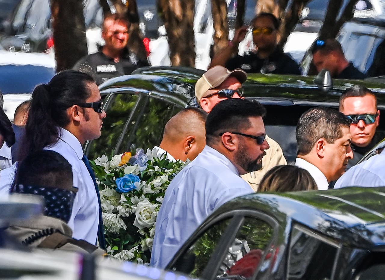 Los portadores del féretro llevan los ataúdes. Cuando se conocieron "floreció en un amor hermoso y amable", cuenta el obituario conjunto de la pareja online.