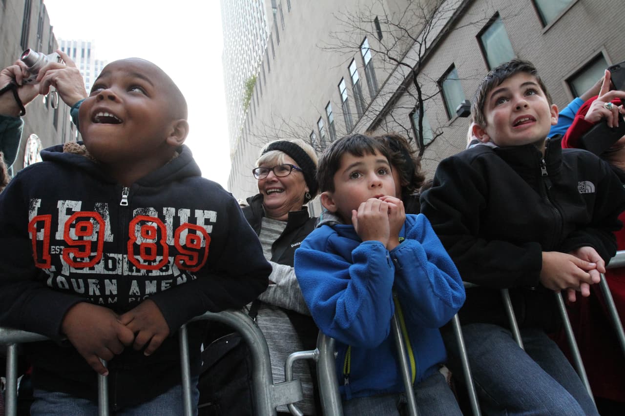 El pequeño Adrián Colon (izquierda) mira con entusiasmo el desfile, junto a otros pequeños.