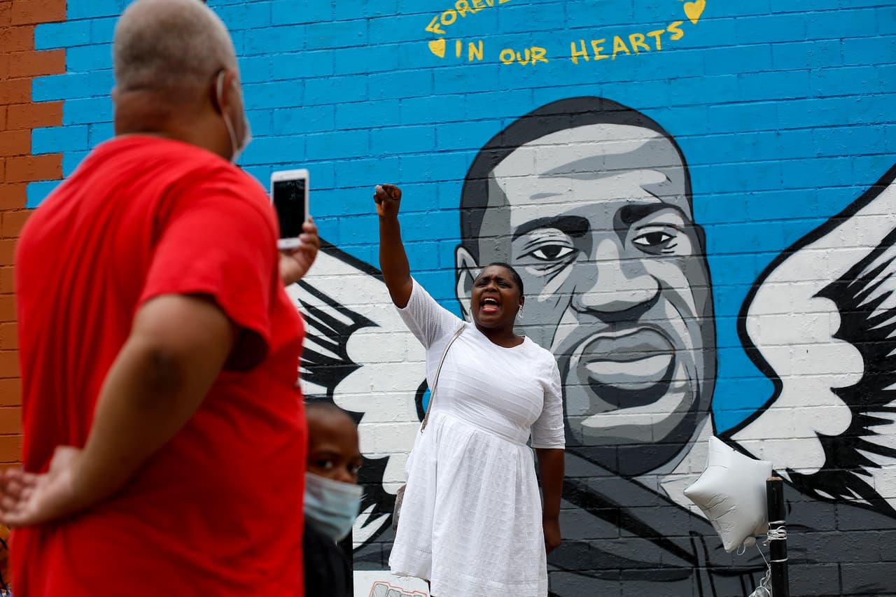 <b>Houston, Texas.</b> Residentes posan frente a un mural de Floyd pintado en la pared de un automercado. En esta ciudad vivió el afroamericano la mayor parte de su vida, y allí será enterrado el 9 de junio. 
<br>