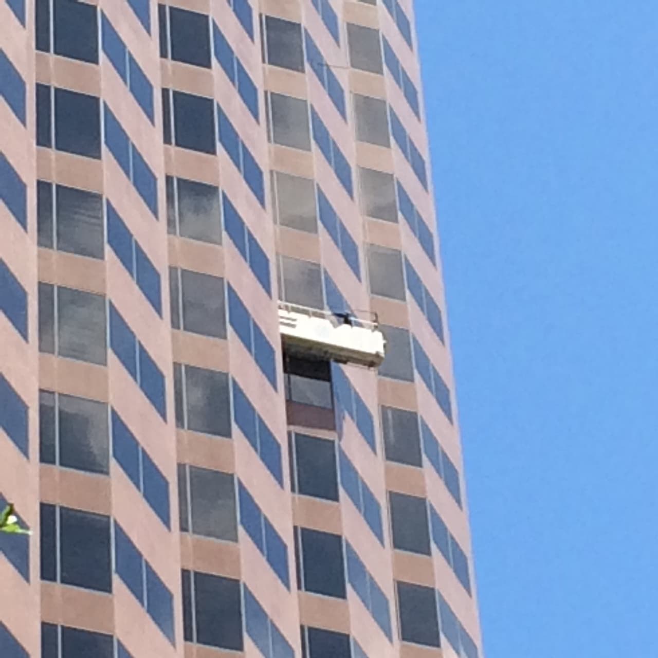 Rescatan sanos y salvos a trabajadores de andamio limpia vidrios