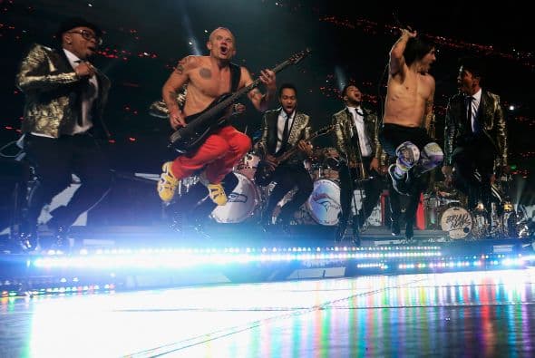 Un cuidado estilismo retro, una banda llena de energía y una particular mezcla de soul y rock sirvieron al cantante Bruno Mars para cautivar a la millonaria audiencia del Super Bowl durante el descanso de la gran cita anual del fútbol americano. Mars, de sólo 28 años y sobre quien planeaba la duda de si sería capaz de enfrentarse a un escenario de tal calibre, optó por un show directo y contundente. Tras una breve introducción a cargo de un coro de niños, un espectacular solo de batería sirvió para abrir el fuego y dar paso rápidamente al gran éxito "Locked Out of Heaven". Impecablemente vestido con una chaqueta dorada, despachó el tema junto a una banda con una amplia sección de viento que se lució en las coreografías. Sin más dilación, Mars descargó su segundo hit, "Treasure", y a continuación demostró su capacidad para fusionar el soul, el pop y el rock integrando en su espectáculo a los Red Hot Chili Peppers. La banda de Anthony Kiedis y Flea puso a saltar a todo el estadio Metlife con su clásico "Give it Away". Los rockeros californianos, a pecho descubierto como manda la tradición, solo necesitaron un par de minutos para demostrar que siguen en buena forma y ceder de nuevo el protagonismo a Mars.