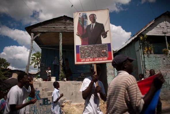 Aristide, un ex sacerdote y el primer presidente de Haití elegido democráticamente, fue forzado a huir del país en febrero del 2004 debido a una violenta revuelta. Aún cuenta con un gran apoyo, particularmente en las barriadas de Puerto Príncipe.