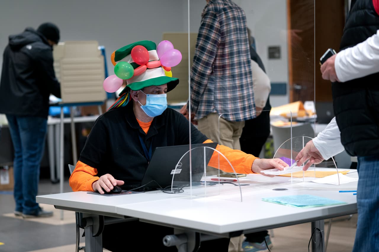 Un trabajador de un centro electoral durante el día de Halloween en McLean, Virginia.