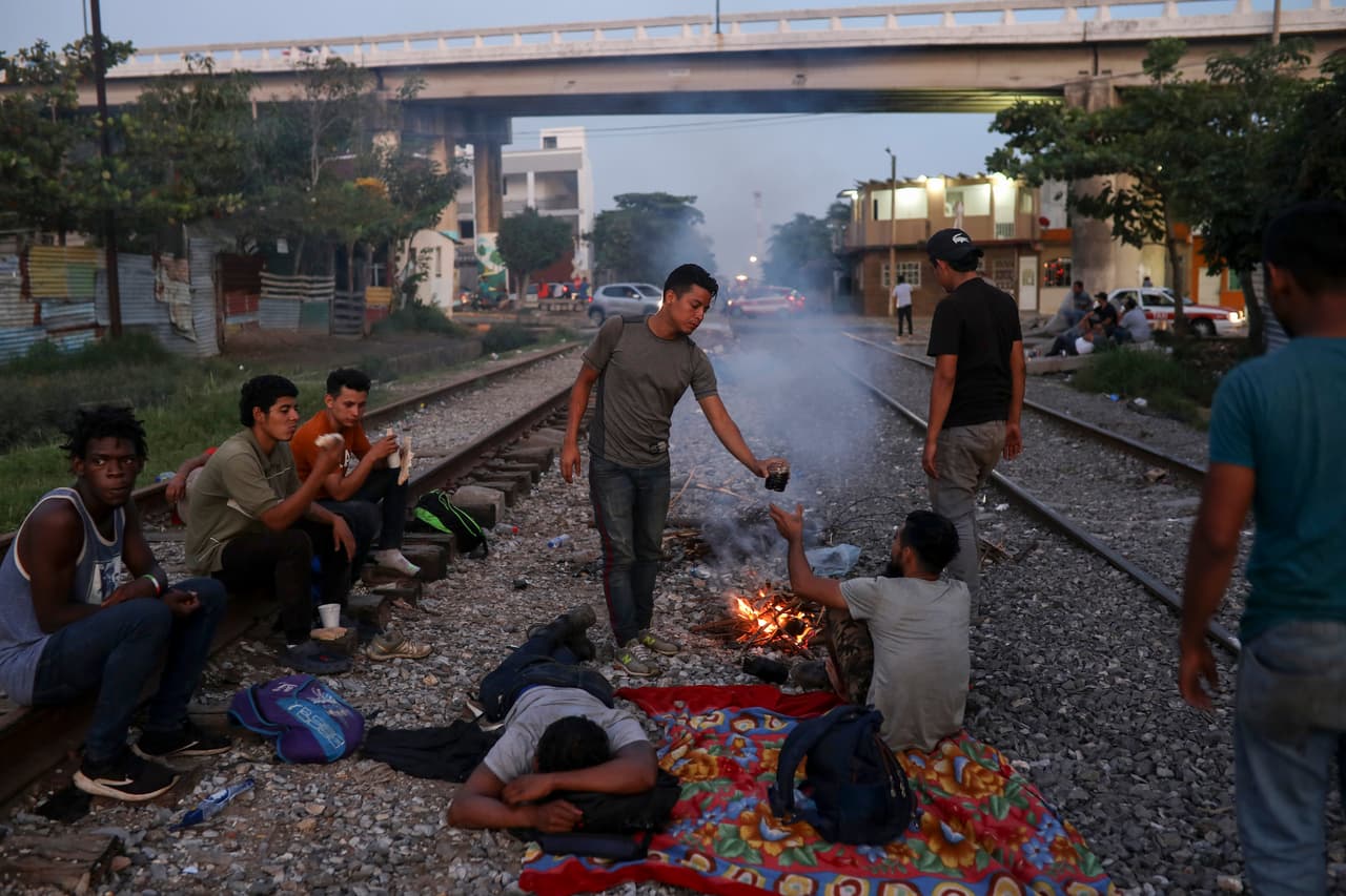 En esta foto del 21 de noviembre de 2019, migrantes centroamericanos esperan a que pase un tren en Coatzacoalcos, en el estado de Veracruz, México. Desde que llegó al poder, el presidente estadounidense Donald Trump ha impulsado duras políticas migratorias. (AP Foto/Félix Márquez)
