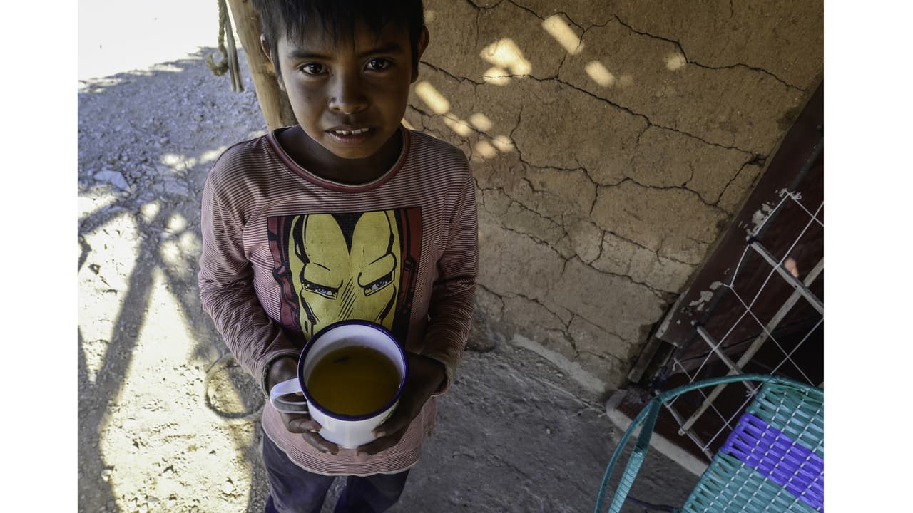 Carlos Jusayu, 11, sostiene una taza de agua sucia del pozo más próximo a su domicilio. Una sequía de tres años en la península de La Guajira de Colombia ha limitado el acceso de la familia Jusayu al agua limpia.