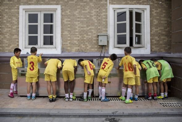 Los niños toman agua de los bebederos comunitarios.