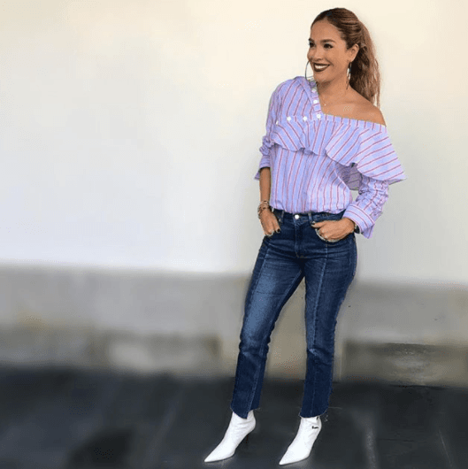 Nos encanta la combinación de esta blusa asimétrica y estos 'cropped jeans'. Las botas blancas son tendencia esta temporada.
