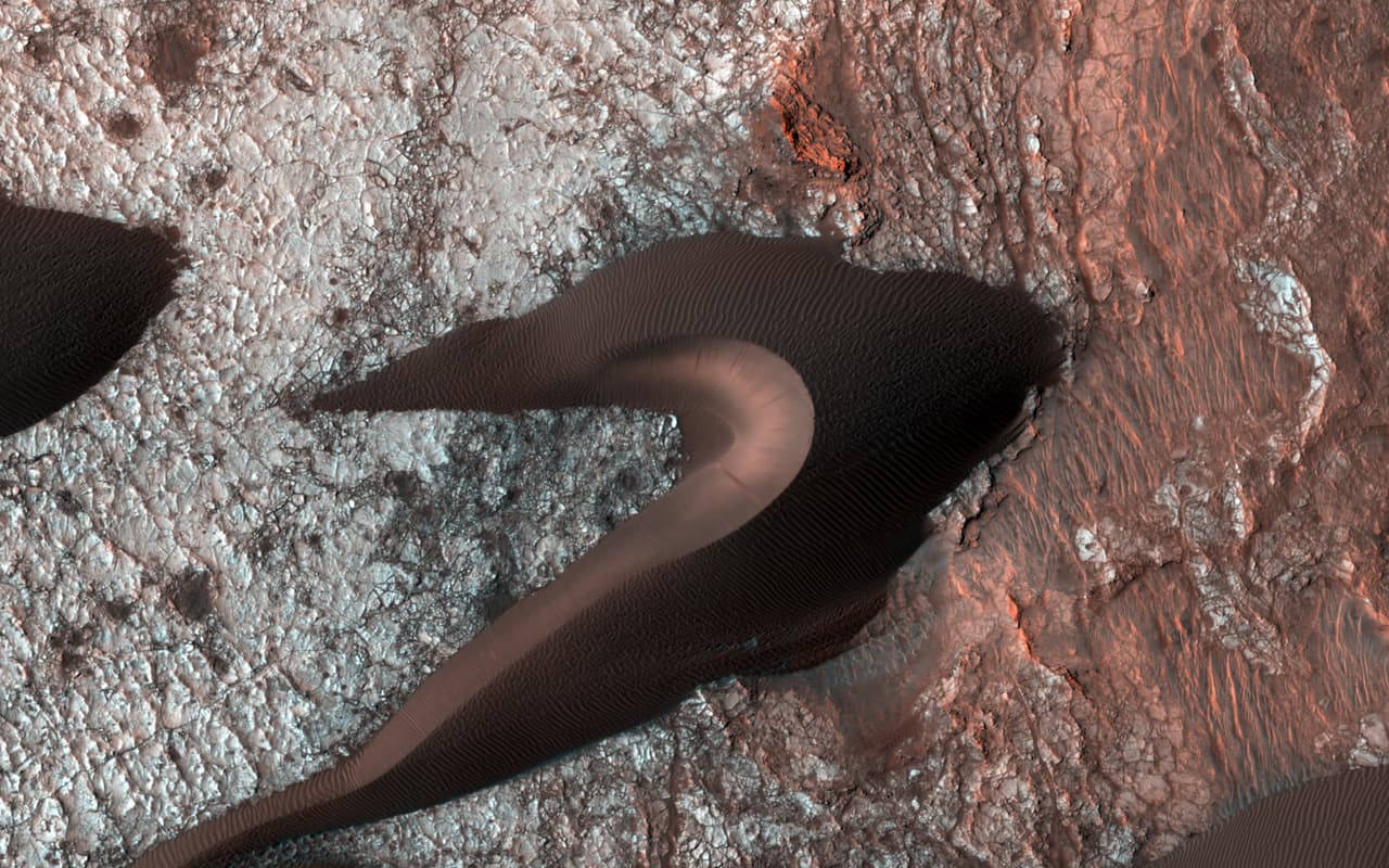 HiRISE, la cámara de alta resolución a bordo del orbitador Reconnaissance, a menudo toma fotos de las dunas de arena marcianas para estudiar sus movimientos. Estas imágenes proporcionan información sobre la erosión, los patrones del viento y el clima. Al mirar más allá de las dunas, estas imágenes también revelan la naturaleza del suelo fijo que está por debajo.
