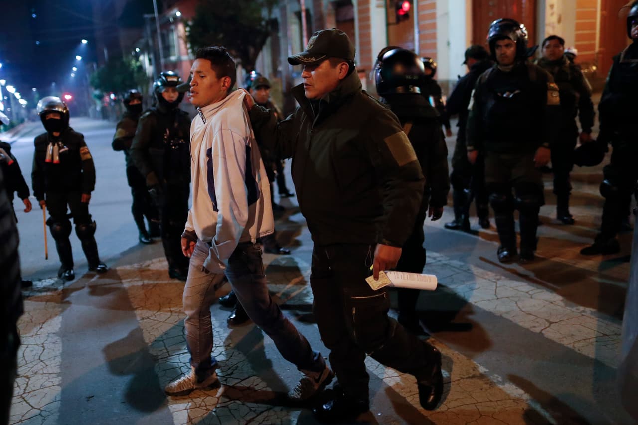 La policía se lleva a un hombre detenido durante los enfrentamientos. Según la prensa boliviana, en medio del caos se han incendiado casas y saqueado negocios, mientras las autoridades hacen grandes esfuerzos para controlar la situación.