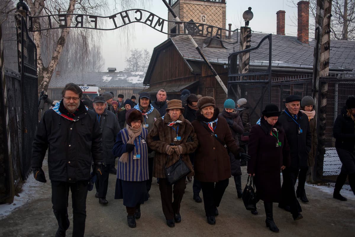 Los visitantes caminaron despacio bajo la famosa puerta, que muestra las palabras "Arbeit Macht Frei" ("El trabajo os hará libres") y llegaron en grupo hasta el muro de las ejecuciones, donde rezaron y colocaron velas encendidas.