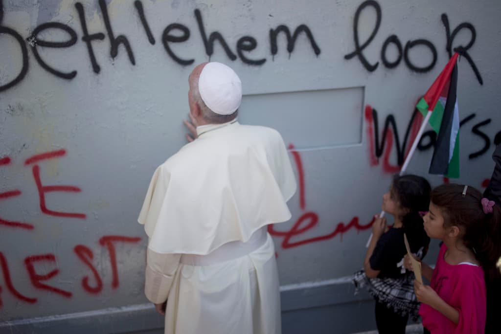ARCHIVO - El papa Francisco ora junto a un muro erigido por Israel en su camino a una misa en la Plaza del Pesebre junto a la Iglesia de la Natividad, donde según la tradición nació Jesucristo, el domingo 25 de mayo de 2014, en Belén, Cisjordania. (AP Foto/Ariel Schalit, archivo)